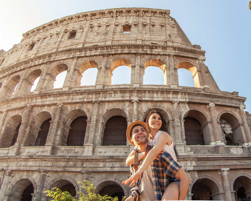 Young happy couple having fun at Colosseum, Rome.